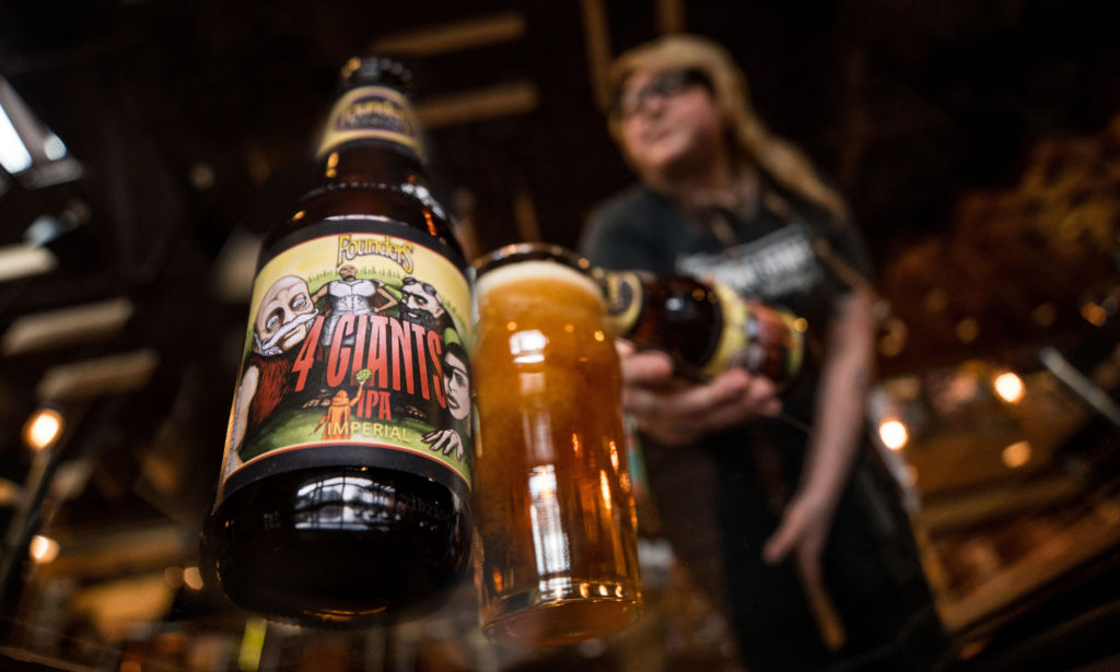 Women pouring Founders 4 Giants Indian Pale Ale into beer glass
