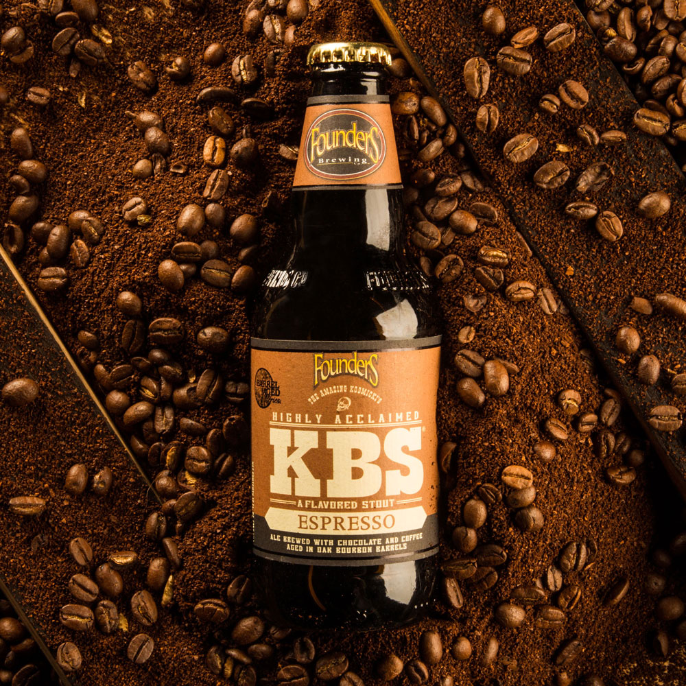 kbs espresso bottle laying on coffee beans and bourbon barrel staves