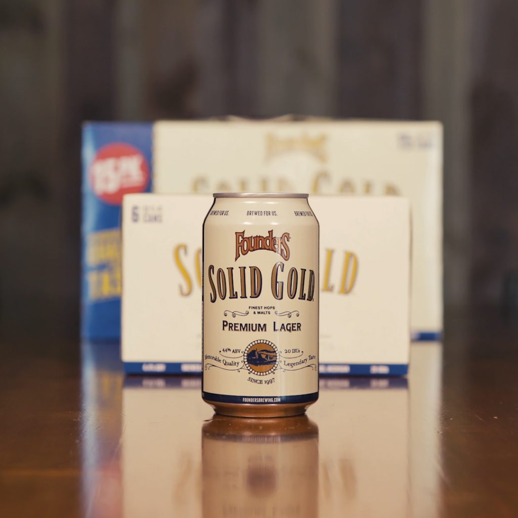 Founders Solid Gold Premium Lager beer can in front of case