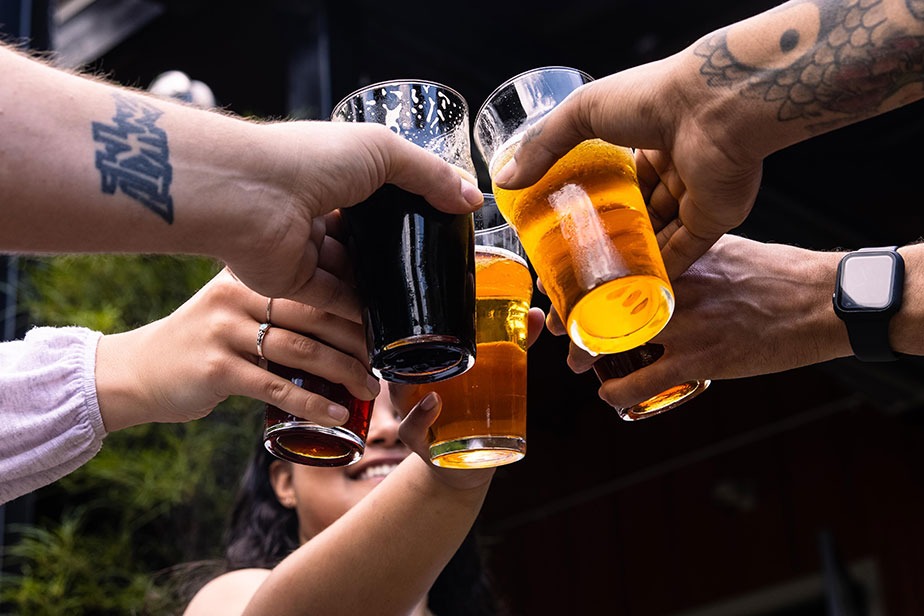 A group of people cheering draft beer